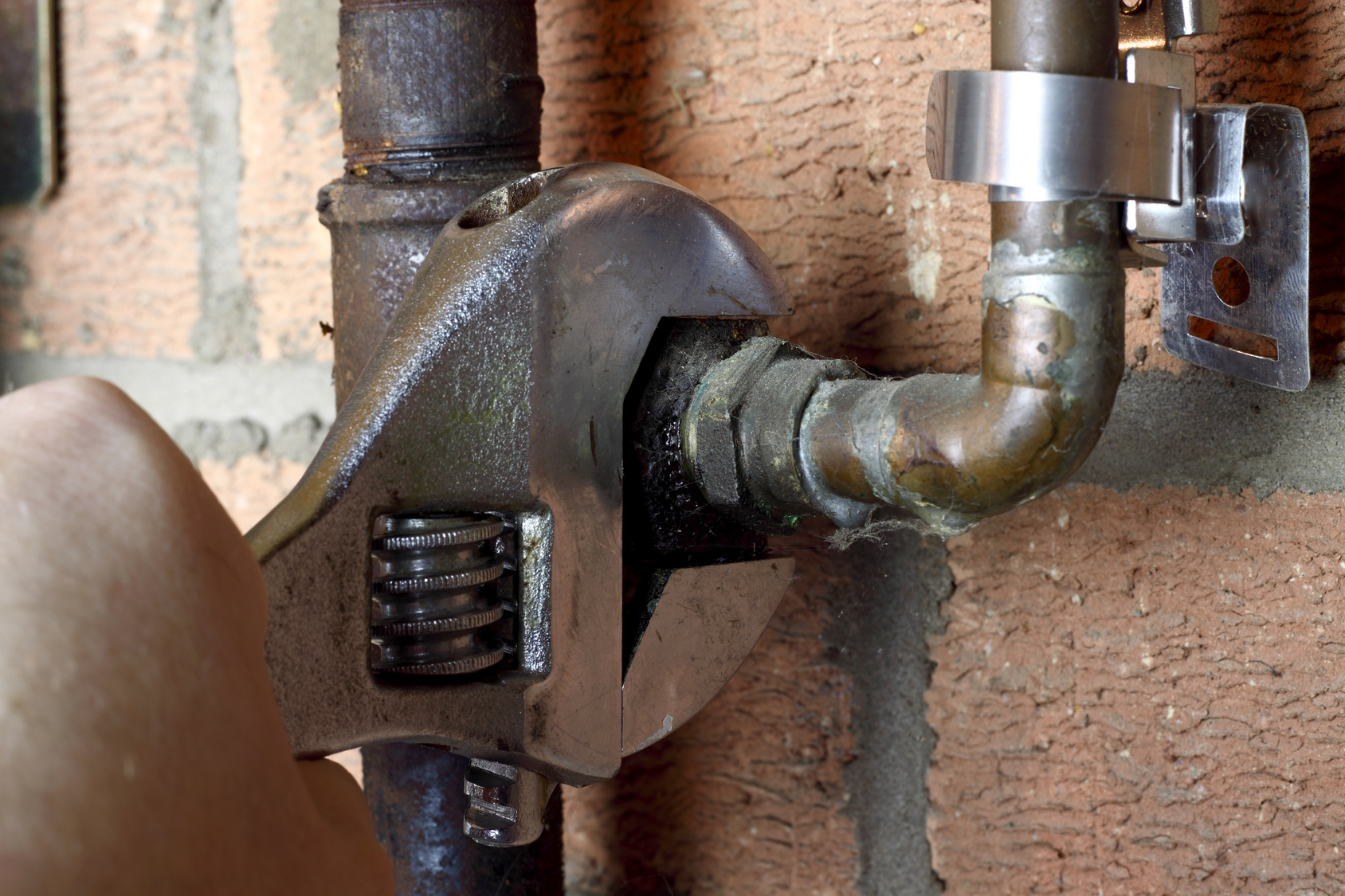 A wrench tightening a gas pipe connection